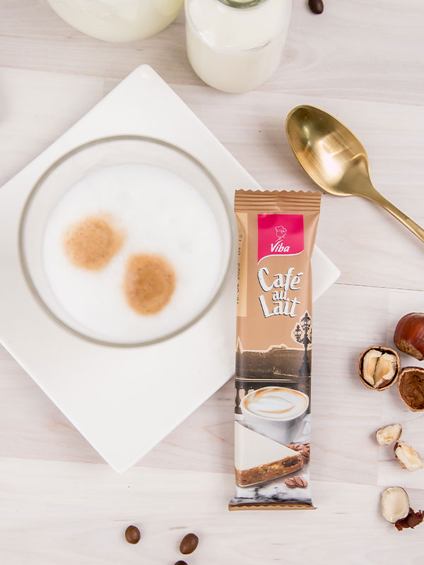 Viba Genussriegel Café auf Lait liegt neben einer Tasse Milchkaffee