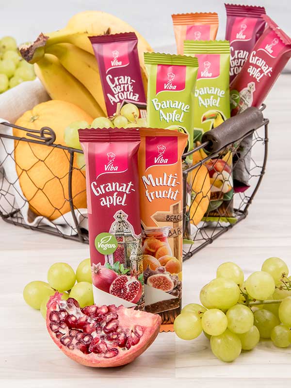 Viba Genussriegel Multifrucht steht vor einem Obstkorb