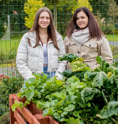 Die Azubis Jessica und Madeline vor dem selbstgebauten Hochbeet