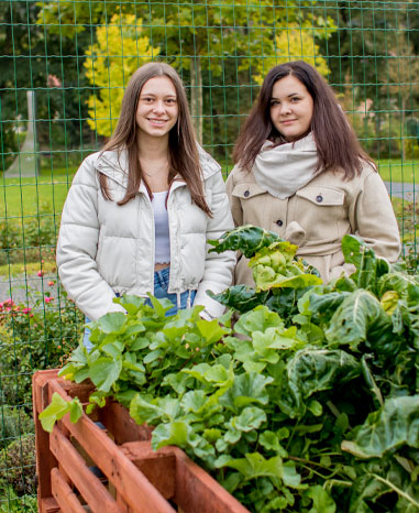 Die Azubis Jessica und Madeline vor dem selbstgebauten Hochbeet