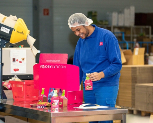 Lagerlogistiker-Samuel Absolvent Samuel beim Packen der Pakete für den Onlineshop