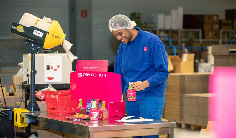 Lagerlogistiker-Samuel Absolvent Samuel beim Packen der Pakete für den Onlineshop