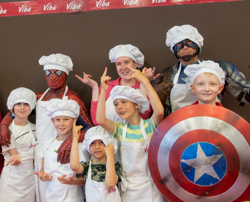 Superhelden Spider-Man und Captain America mit Kindern in der Confiserie