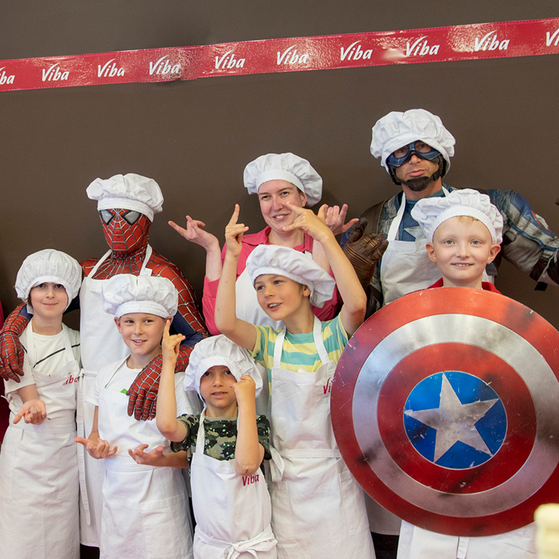 Superhelden Spider-Man und Captain America mit Kindern in der Confiserie