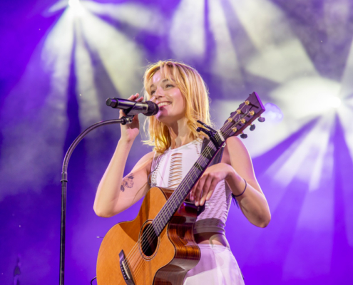 LOTTE LOTTE steht lächelnd mit Gitarre am Mikrofon