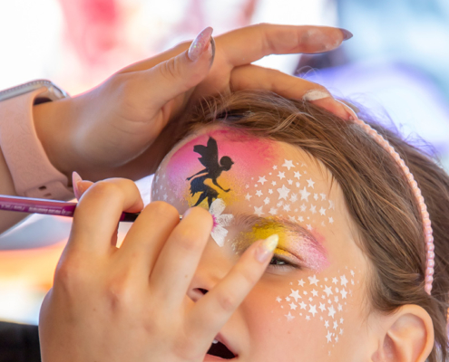 Kinderschminken Mädchen wird im Gesicht geschminkt