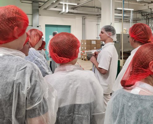 Industrie InTouch Azubi Walter erklärt interessierten Schülern, wie Nougat hergestellt wird.