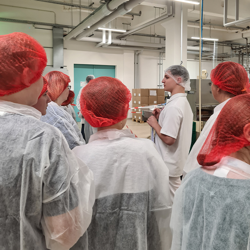 Industrie InTouch Azubi Walter erklärt interessierten Schülern, wie Nougat hergestellt wird.