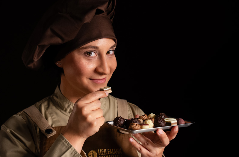 Mitarbeiterin der Confiserie HEILEMANN mit Pralinen in der Hand
