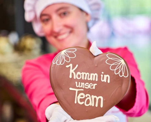 Confiseurin mit beschrifteter Schokolade: Komm in unser Team
