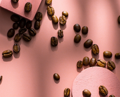 Kaffeebohnen auf rosa Hintergrund
